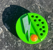 Broche verde con piedra naranja.